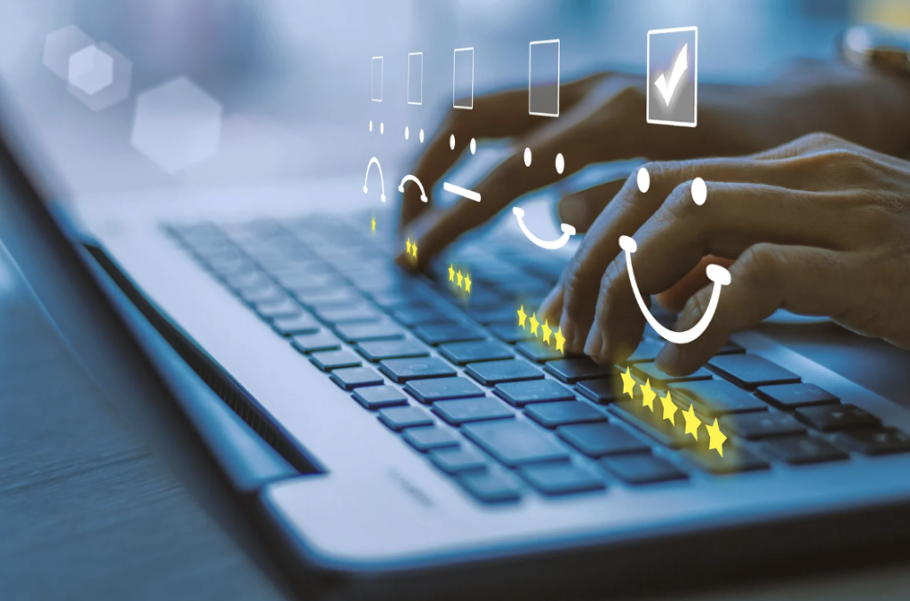 Hands typing on a laptop with glowing smiley faces and stars representing customer satisfaction feedback